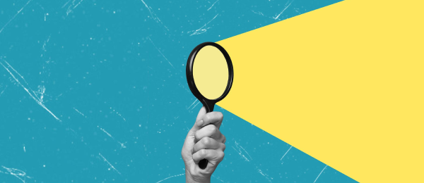 Hand holding magnifying glass symbolizing background checks and candidate verification in hiring